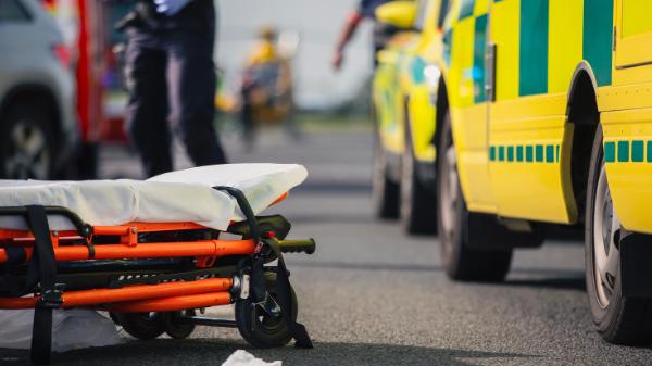 Ambulans med bår som ligger på marken