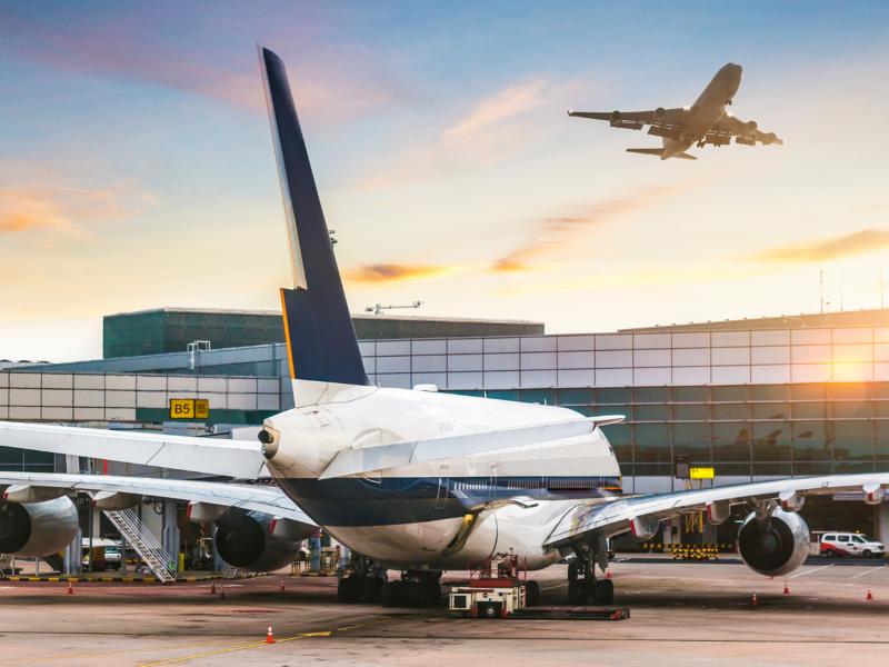 Arbetare på en flygplats med hörselkåpor med Push to Talk