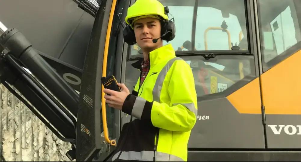 Byggarbetare med Push to talk komradio och hörselkåpor med push to talk