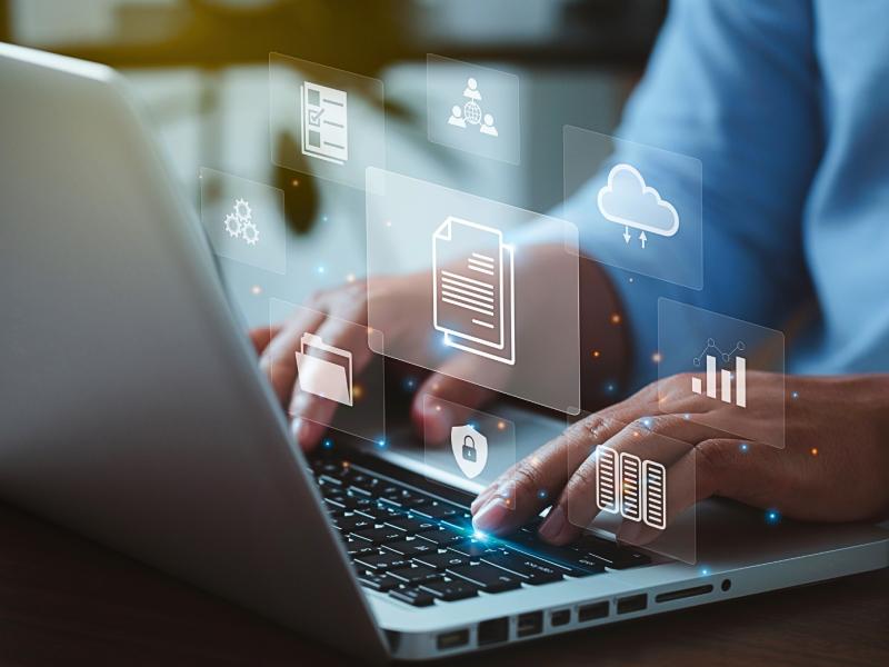 En människa skriver på en dator med en illustration som visar på människor som kommunicerar i grupp