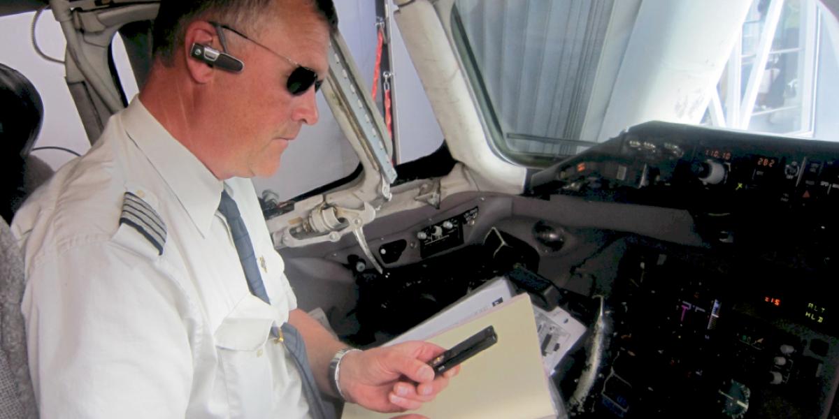 Pilot med blåtands headset och talar genom Push to Talk till sina kollegor.