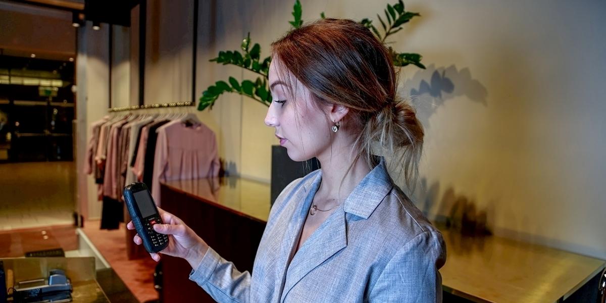 Kvinnlig ensamarbetare med personal larm för ensamarbete i butik